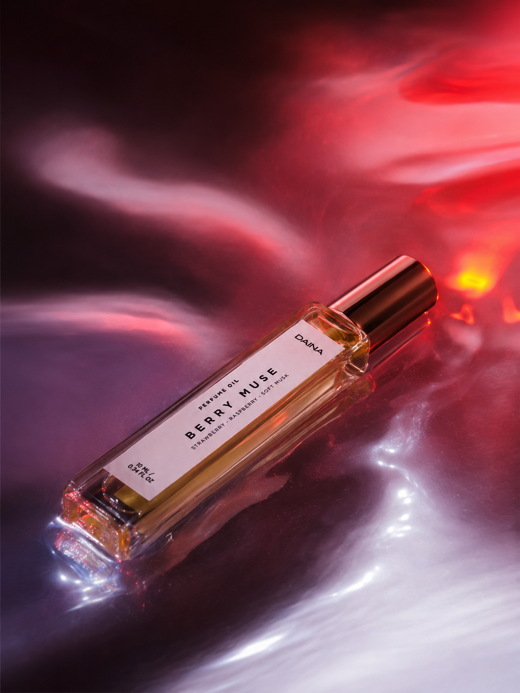 DAINA Berry Muse perfume bottle with rose-gold cap on a smoky dark background with red and pink light effects