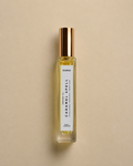 DAINA Caramel Spell perfume oil bottle with gold cap on a beige background