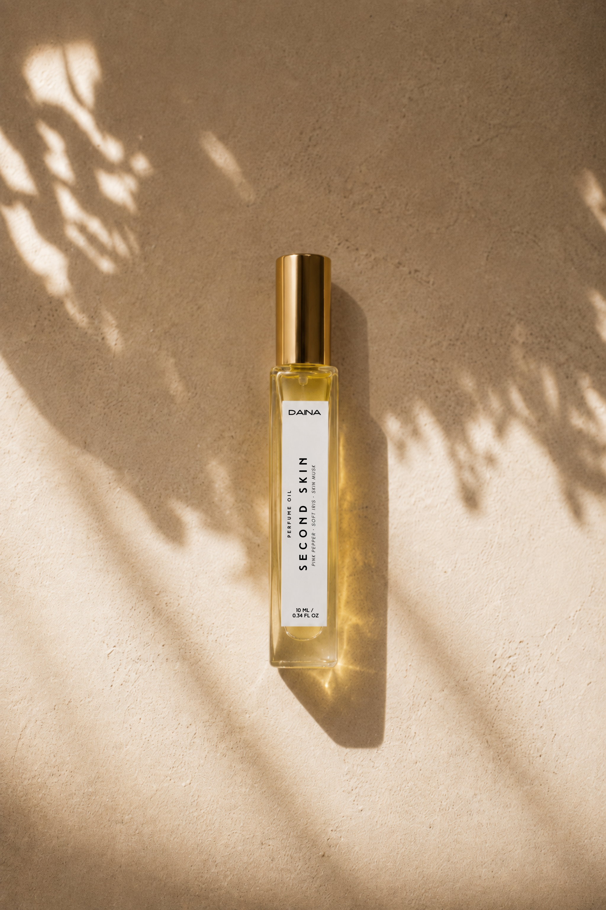 DAINA Second Skin perfume oil bottle in dappled leaf shadows