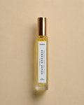 DAINA Solar Goddess perfume oil bottle with gold cap on a beige background