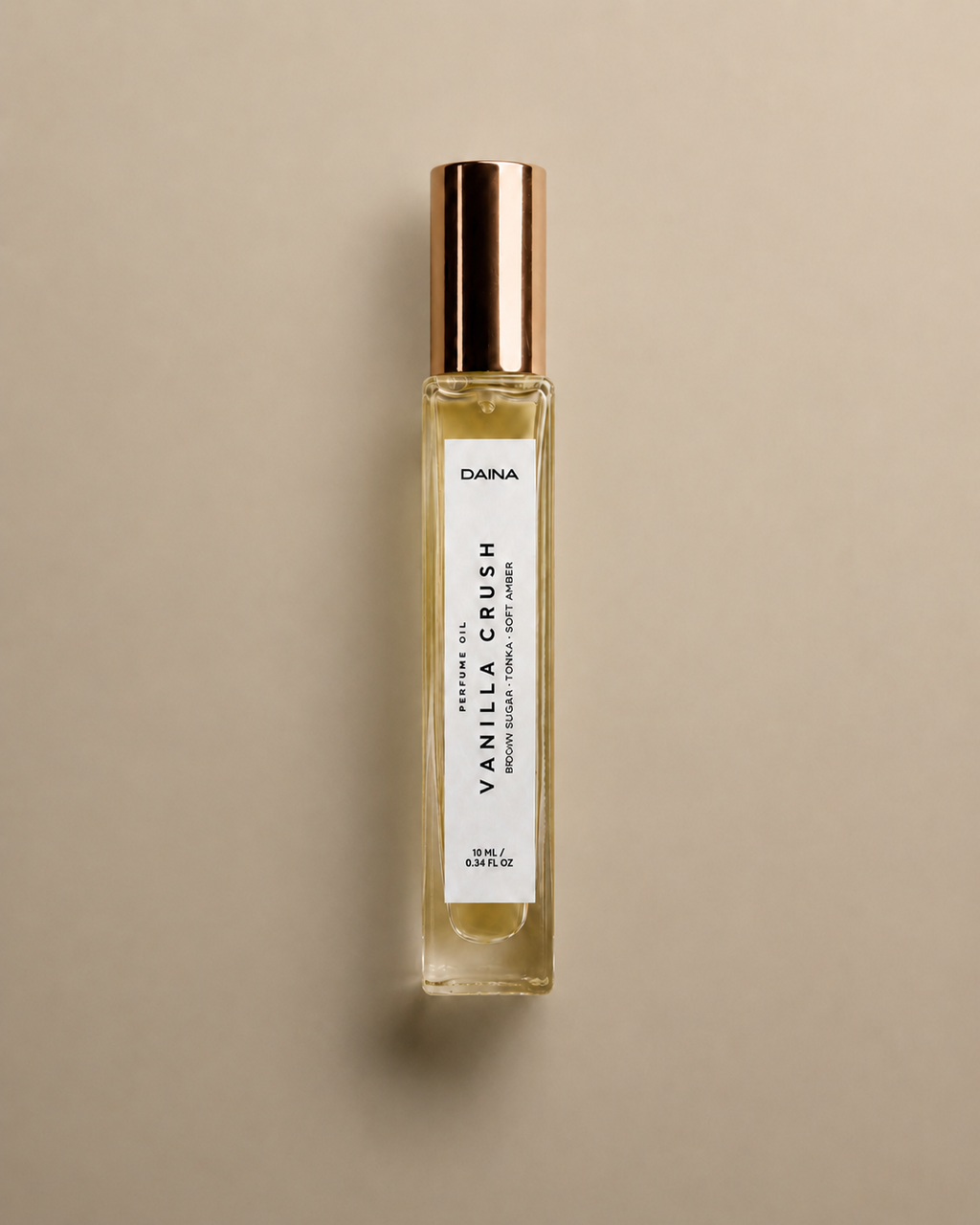 DAINA Vanilla Crush perfume oil bottle with gold cap on a beige background