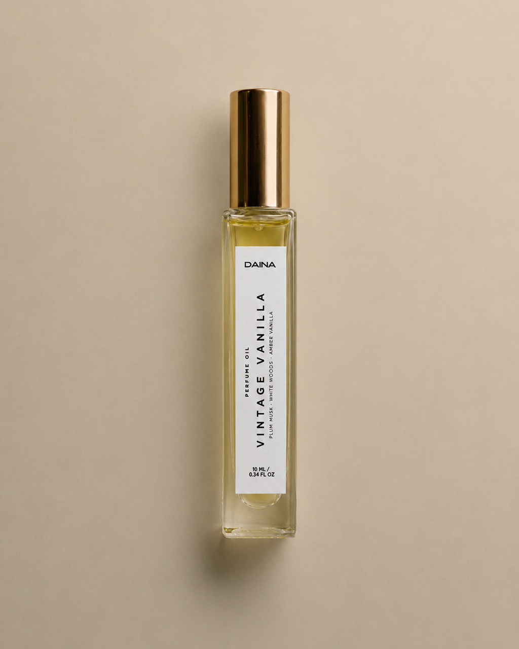 DAINA Vintage Vanilla perfume oil bottle with gold cap on a beige background