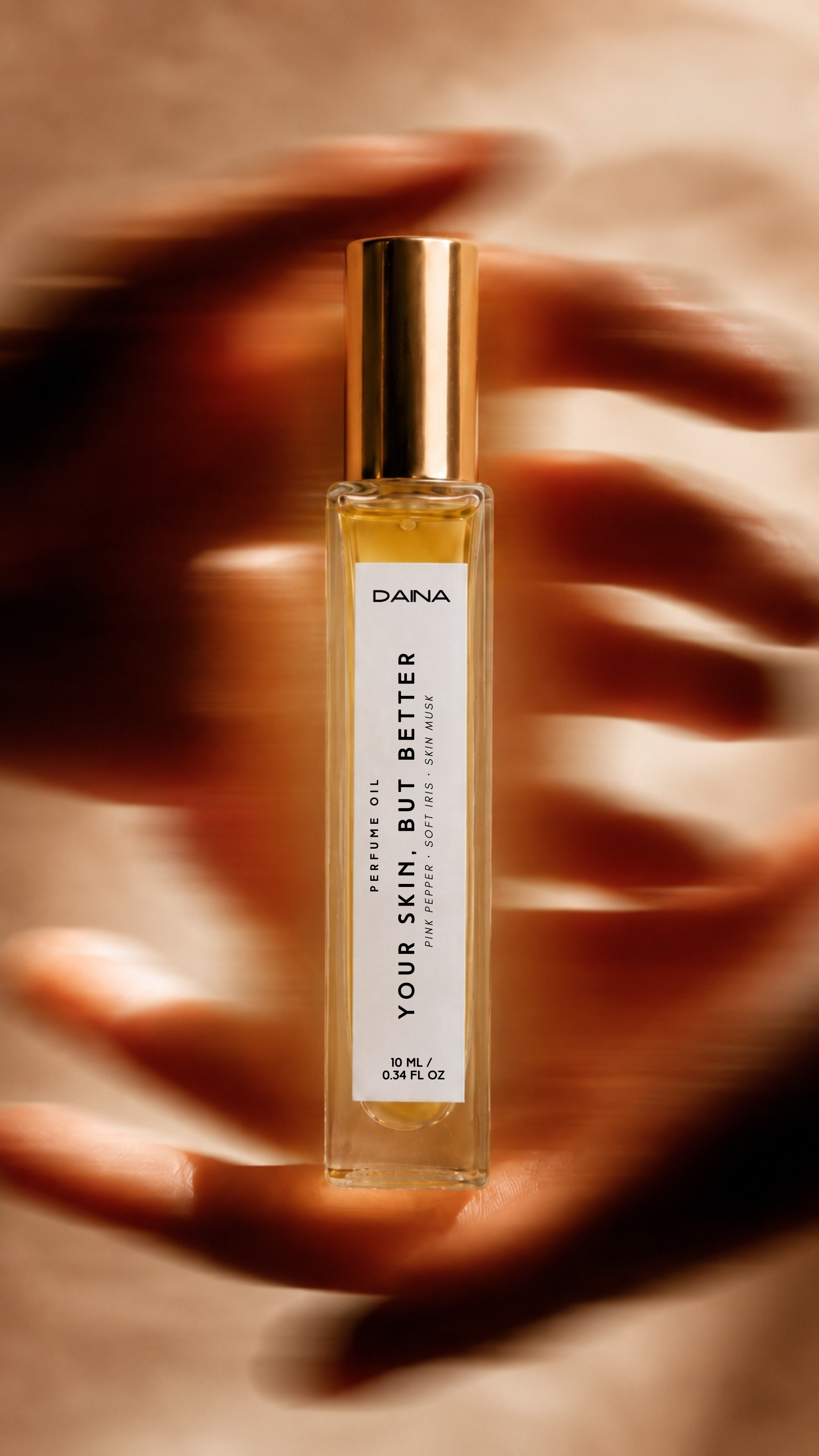 DAINA Your Skin But Better perfume oil framed by warm hands.