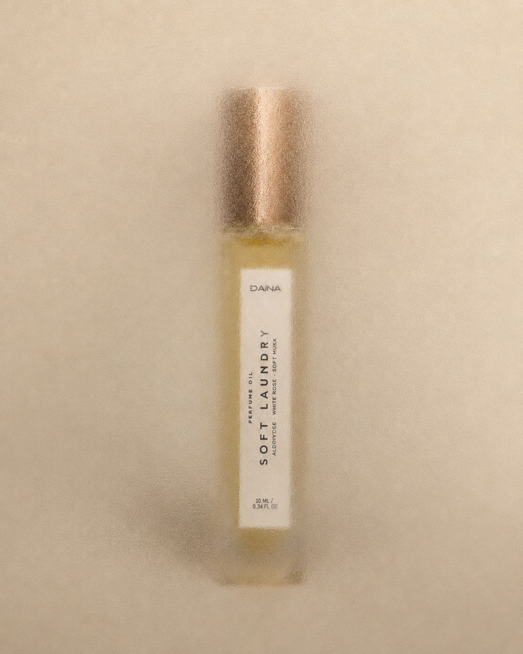 DAINA Soft Laundry perfume oil roll-on bottle, 10 ml, on beige background
